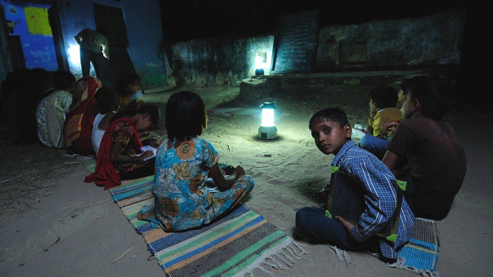 Children studying by solar light at a night school in Ajmer, Rajasthan