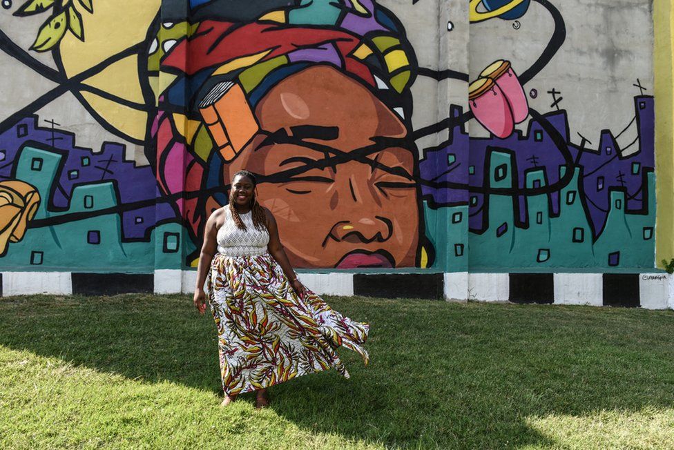 Брион Гилл, также известная как леди Брион, член молодых балтиморских активистов «Лидеры прекрасной борьбы», позирует для портрета перед фреской в ​​Балтиморе, штат Мэриленд, США. 30 июля 2019 г.