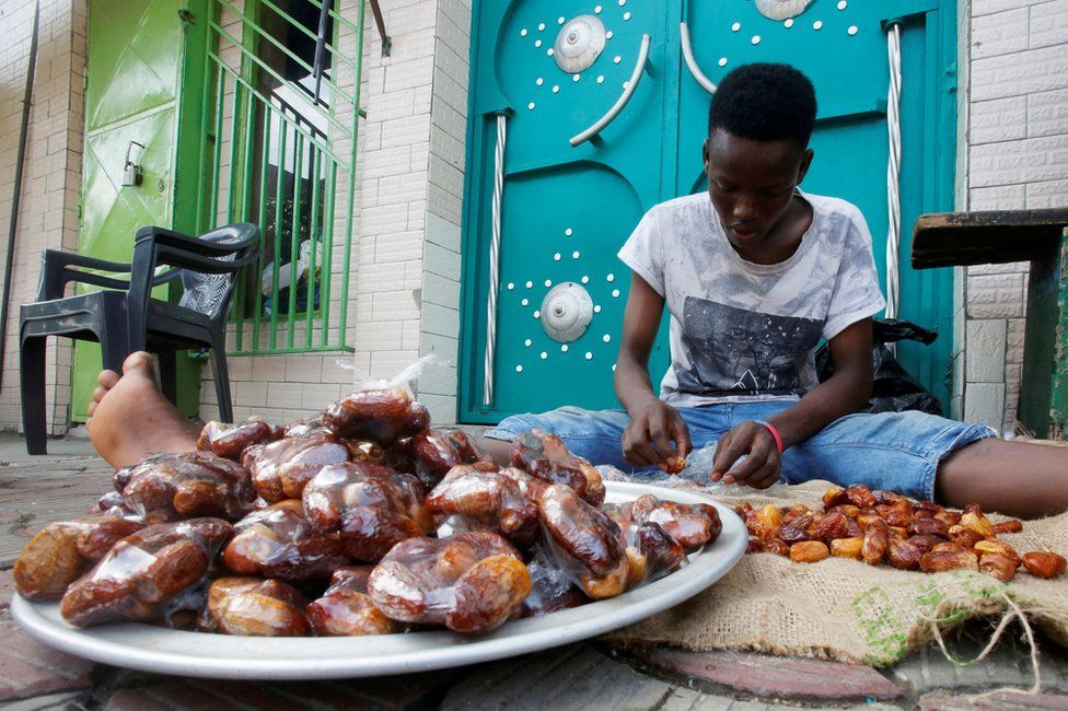 A boy bags dates in front of a mosque in Abidjan, Ivory Coast, on 24 April.