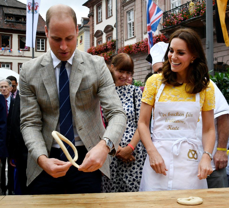 Britain's Prince William, Duke of Cambridge, and his wife Kate, the Duchess of Cambridge, form pastry to pretzels during their visit of the market in the historic centre of southern German town of Heidelberg on 20 July 2017.