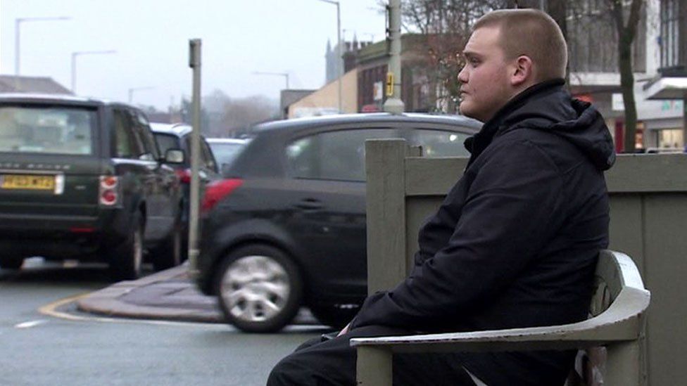 Sam North, 23, sitting on bench