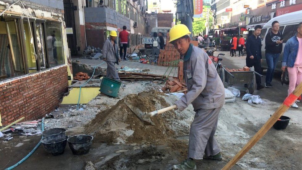 Beijing workers knocking down small shops