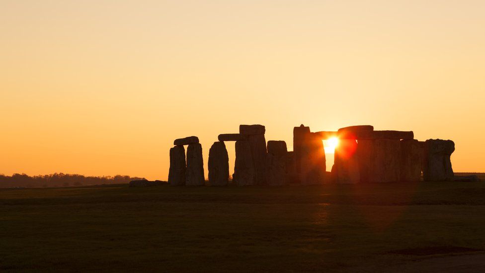 Stonehenge with sun behind monument