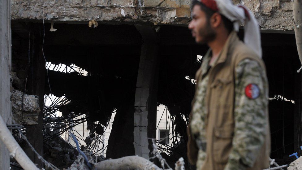 A Yemeni man inspecting air strike damage