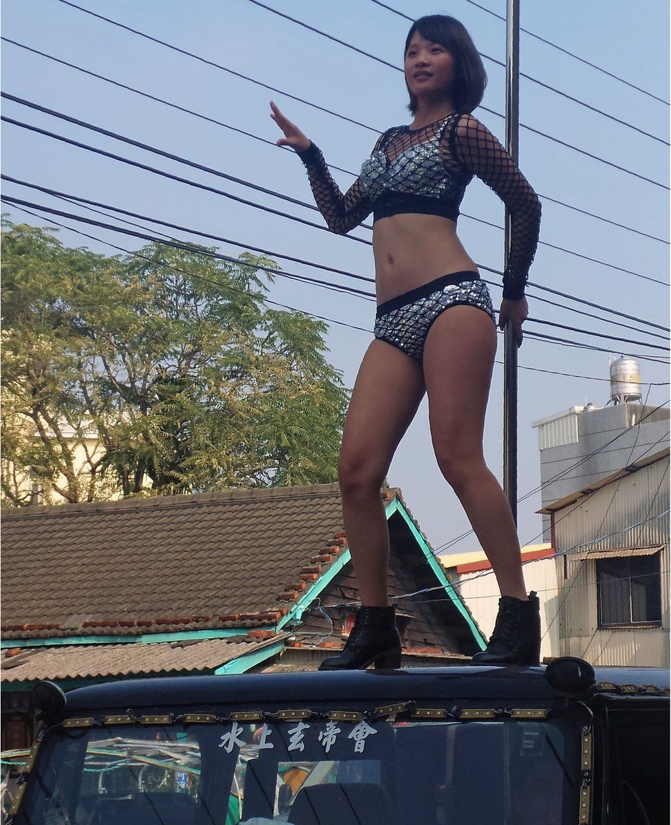 This picture taken on 3 January 2017 shows a pole dancer performing on top of a jeep during the funeral procession of former Chiayi City county council speaker Tung Hsiang in Chiayi City, southern Taiwan.