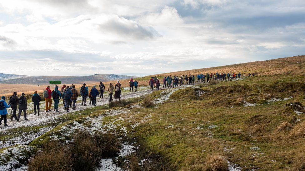 Line of people hiking across Dartmoor.