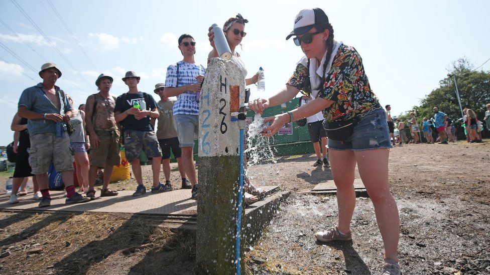 People queue at a water refill point at Glastonbury