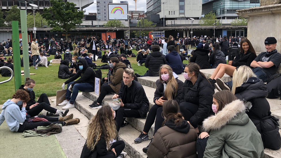 People sitting down at Piccadilly Gardens