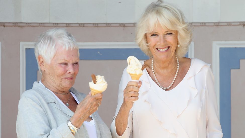 Dame Judi Dench and Camilla, Duchess of Cornwall enjoy an ice cream at Queen Victoria's private beach next to Osborne House during a visit to the Isle of Wight on July 24, 2018 in East Cowes, Isle of Wight, England