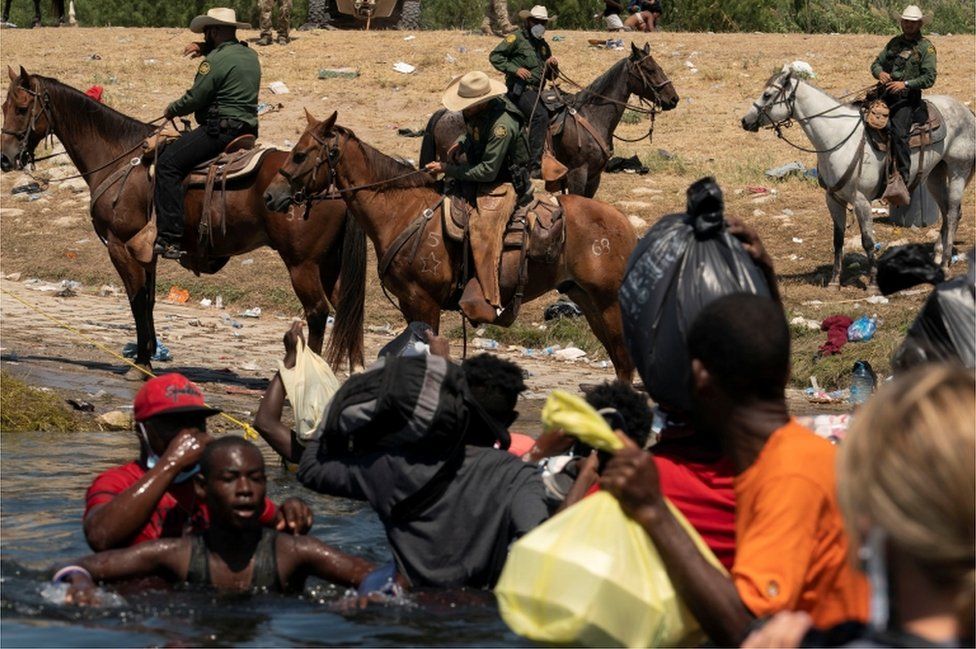 Border Patrol agents on horseback push Haitians back from the US border