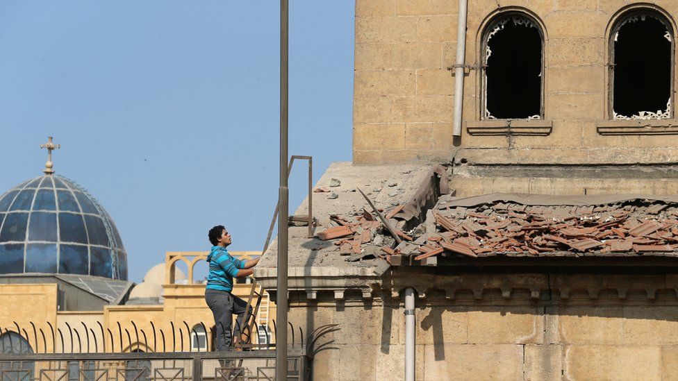 A Christian employee at Cairo's Coptic Cathedral checks for damage from the blast after an explosion inside the cathedral in Cairo