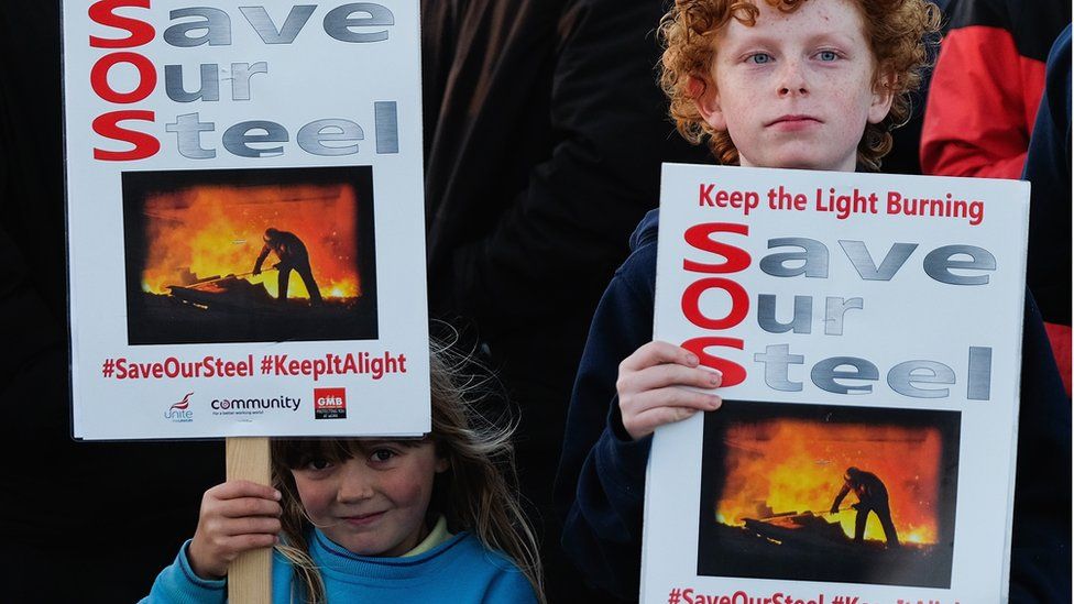 A girl and a boy hold placards as steel workers and their families demonstrate on September 24, 2015 in Redcar, England