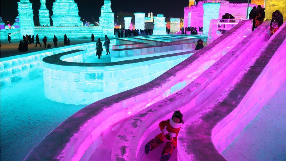 People visit the ice sculptures illuminated by coloured lights at Harbin ice and snow world for the 33rd Harbin International Ice and Snow Festival in Harbin city, China's northern Heilongjiang province, 05 January 2017.