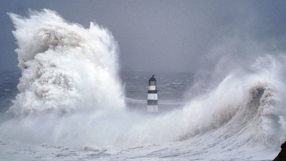 Waves break around lighthouse at Seaham