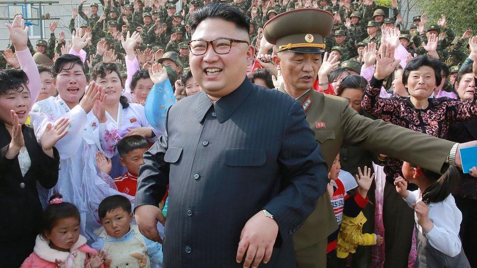 Kim Jong-un on May 5, smiling and standing in front of seemingly joyous citizens