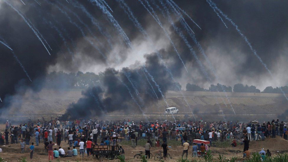 Tear-gas canisters are fired by Israeli forces at Palestinians at a protest on the Gaza-Israel border fence on 4 May 2018