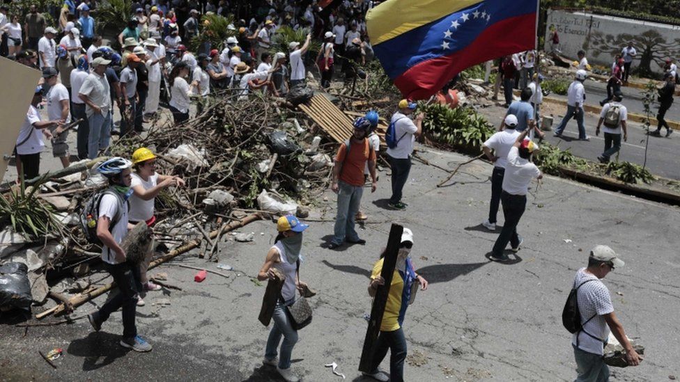 Miembros de la oposición al gobierno de Maduro en una barricada.