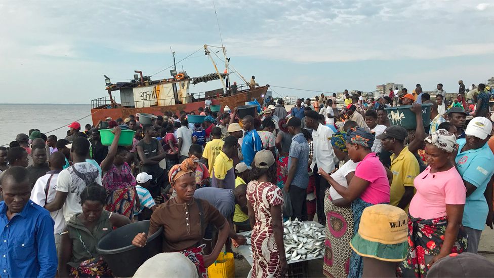 People around a boat in Praia Nova in Beira, Mozambique