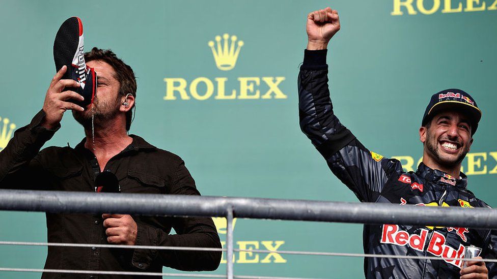 Gerard Butler does a 'shoey' with Daniel Ricciardo at the US Grand Prix
