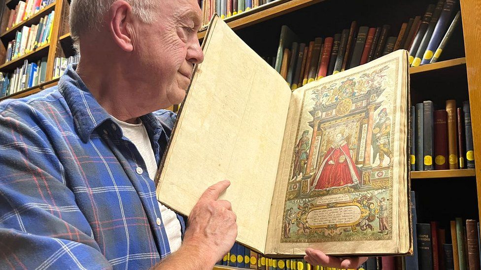 Philip Wilde holding the Saxton Atlas