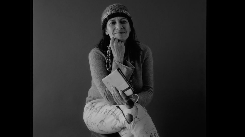 Ali Cobby Eckermann seated and holding a book