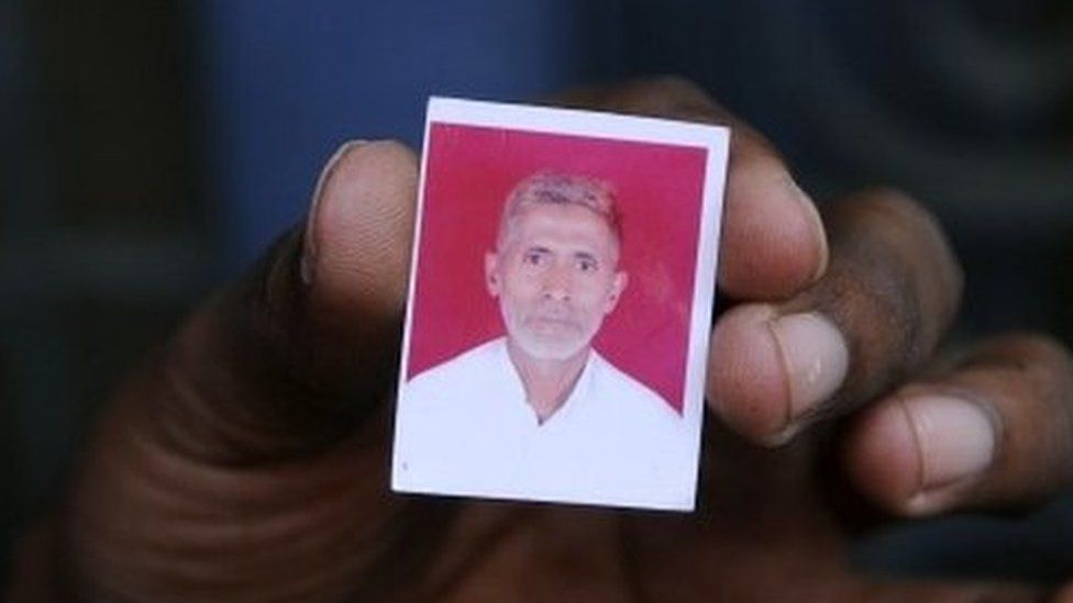 A relative holds a photograph of slain Indian villager Mohammad Akhlaq at his home in the village of Bisada,