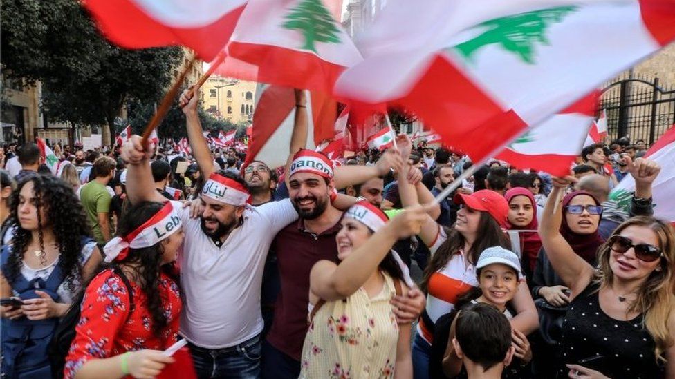 Protesters carry placards during a protest in front the government palace in downtown Beirut, Lebanon, on 20 October 2019.