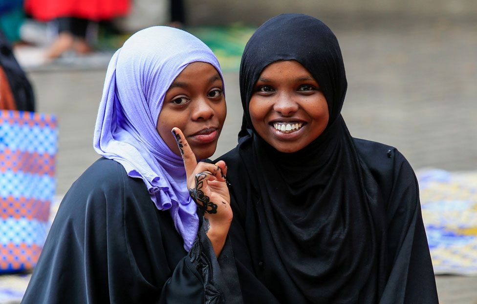 Two young women pose for a photo after performing the Eid prayers at the Masjid Noor Mosque in Nairobi, Kenya
