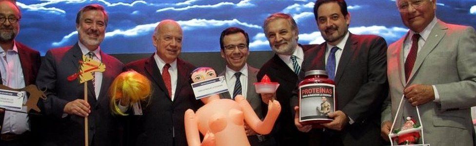 Chile's economy minister Luis Cespedes (C) holds up an inflatable doll during an event of the exporters" association Asexma in Santiago, Chile, December 13, 2016