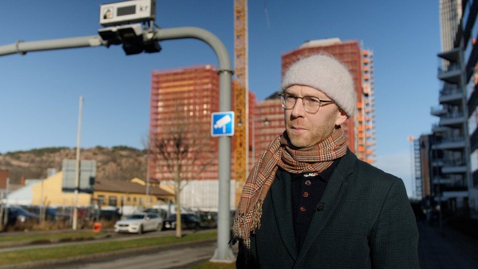 Viktor Hultgren standing next to a set of congestion charging cameras