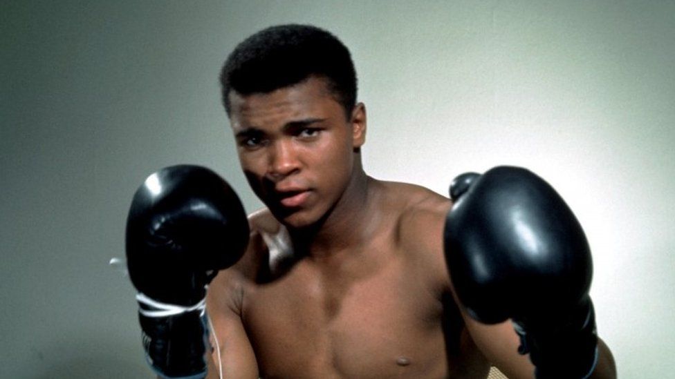 Muhammad Ali poses with gloves (undated photo)