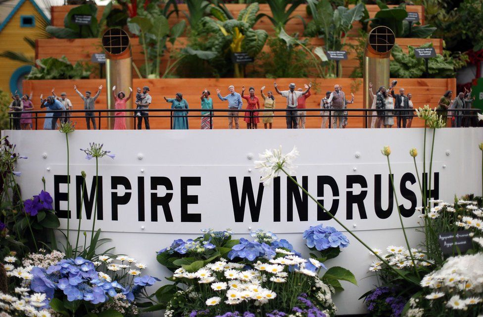 Small figurines adorn a replica of the deck of the Empire Windrush, part of the Windrush Garden on display in the Great Pavillion