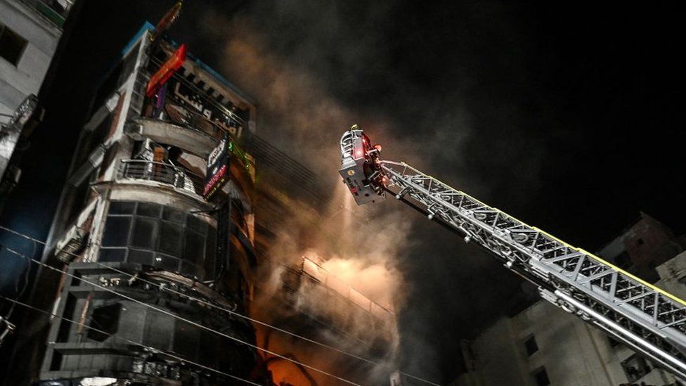 Firefighters work to extinguish a fire in a commercial building that killed dozens of people in Dhaka