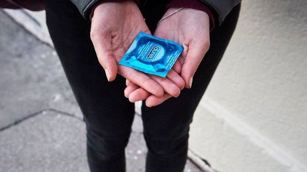 woman holding condom