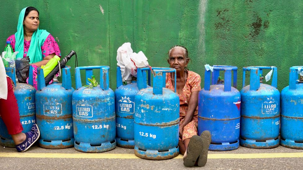 Women sit in line with blue gas cylinders in Slave Island, Colombo, 11 July 2022