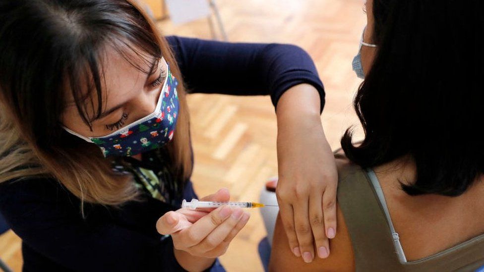 A woman receives a dose of a Covid vaccine at a vaccination centre in Santiago