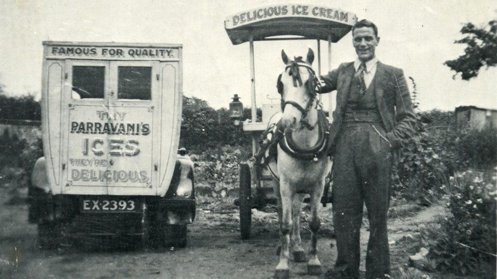 Black and white photo of man with ice cream van and horse
