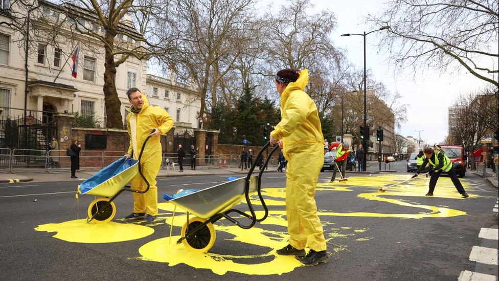Due manifestanti versano vernice gialla sulla strada
