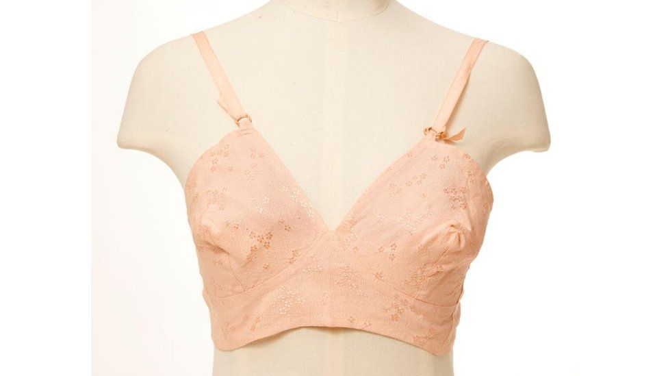 Peach-coloured lace bra from the 1940s on a mannequin