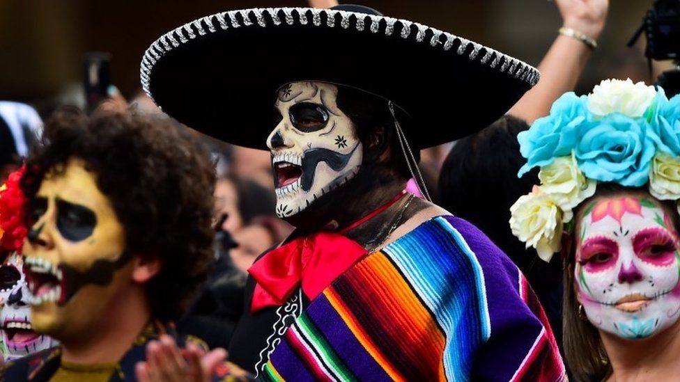 A man wears a colourful poncho and a sombrero during the Catrinas parade in Mexico City