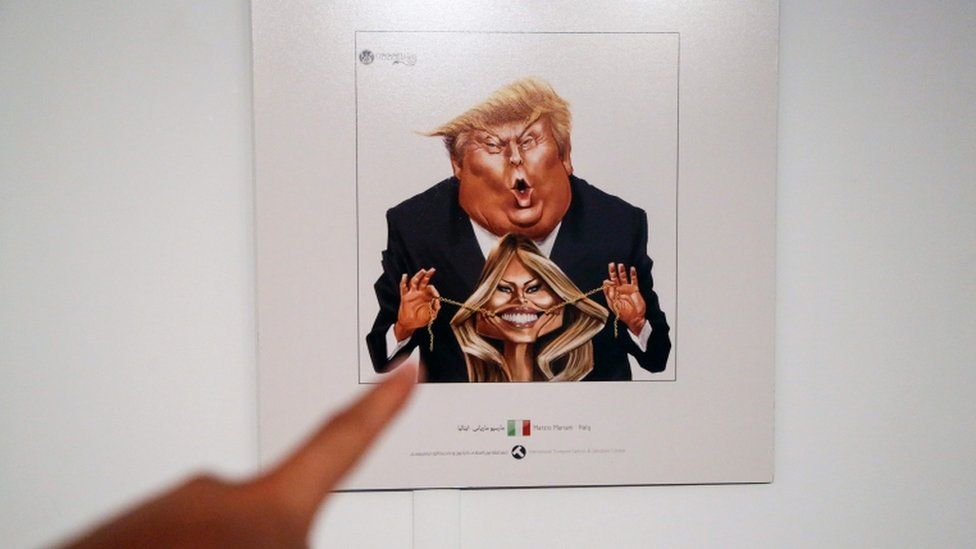 A picture taken on 3 July 3, 2017 shows a cartoon of US President Donald Trump and First Lady Melania Trump on display at an exhibition of the Islamic Republic's 2017 International Trumpism cartoon and caricature contest, in the capital Tehran.