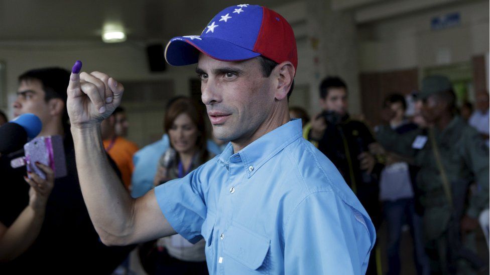 Venezuelan opposition leader Henrique Capriles shows his ink-stained finger after casting his vote at a polling station during a legislative election, in Caracas December 6, 2015.