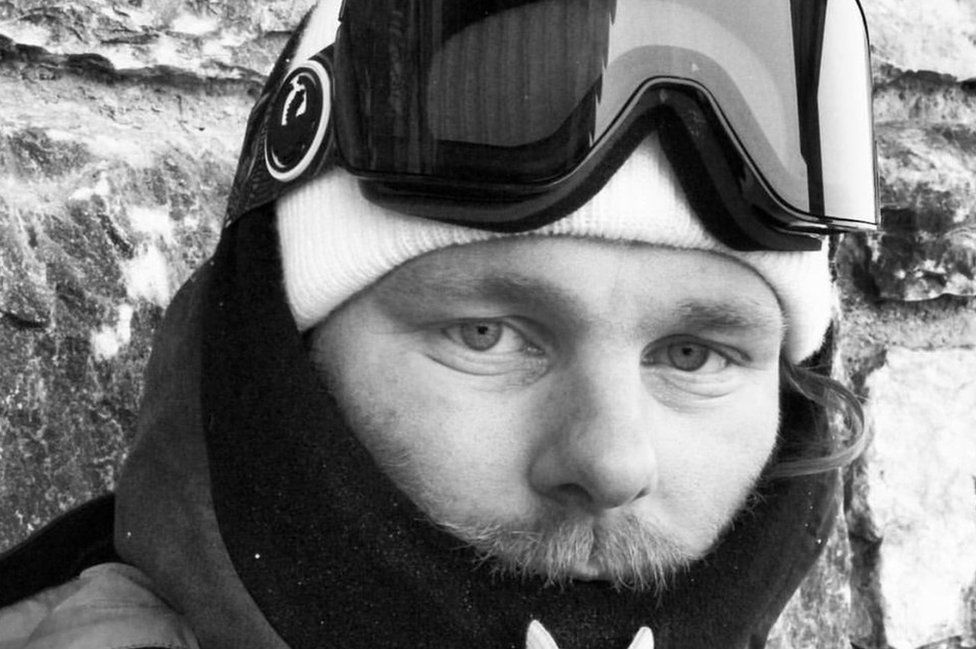 Close-up, black and white image, of Owen Pick in his ski gear