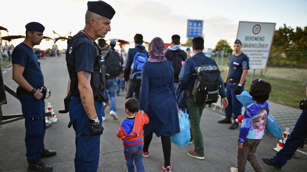 Migrants arrive at a border point between Croatia and Hungary where they will be transported by bus through to Austria on September 21, 2015