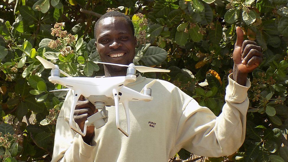A cashew farmer in Benin with a drone supplied by TechnoServe