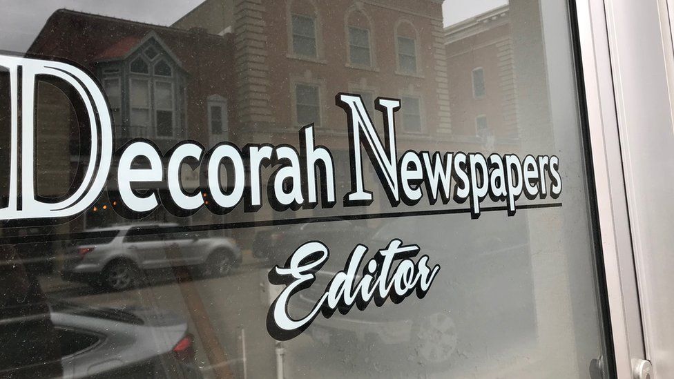 Window sign showing 'Decorah Newspapers' logo