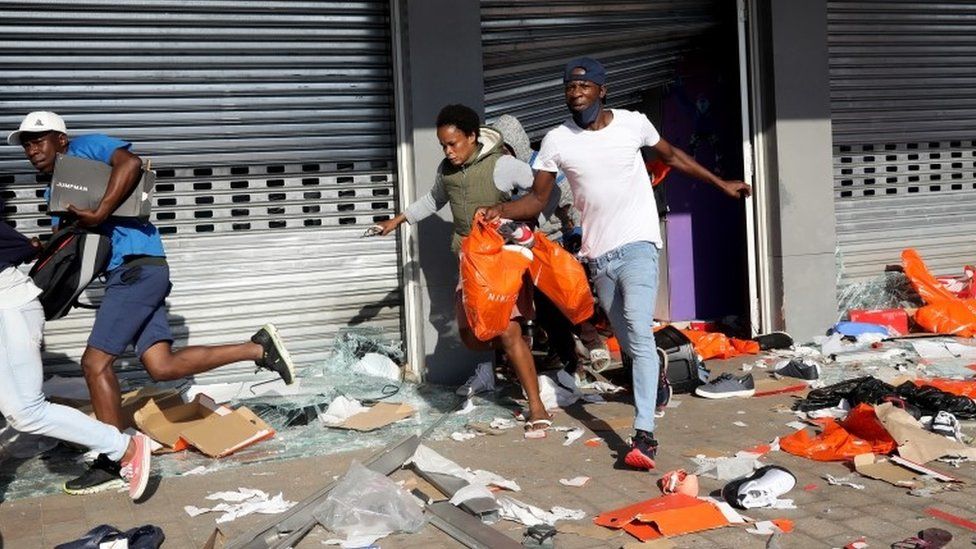 Мародеры опустошают магазин в Спрингфилдском торговом центре во время акции протеста в Дурбане, Южная Африка, 12 июля 2021 г.