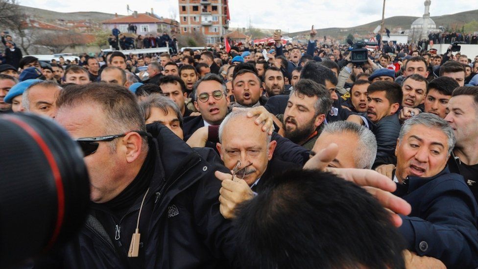 Kemal Kilicdaroglu being jostled by crowds at a funeral