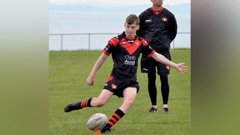 Cameron Taylor kicks a rugby ball
