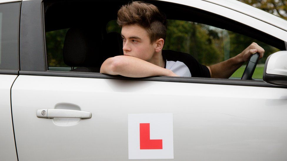 Young driver with L on his car door